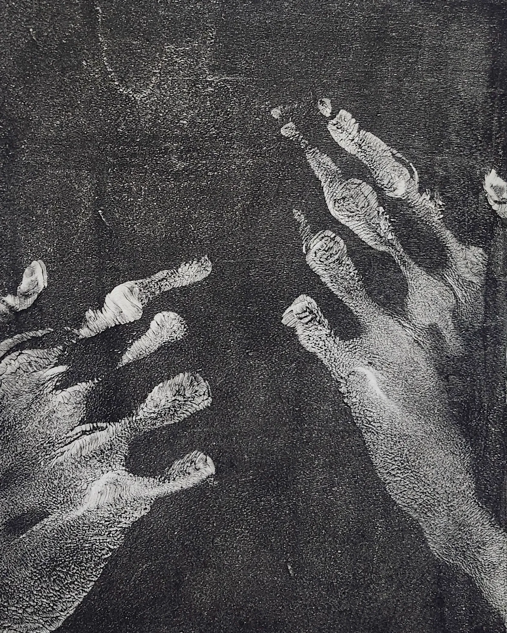 High-contrast black-and-white handprint, fingers spread and reaching diagonally across a dark textured ground.