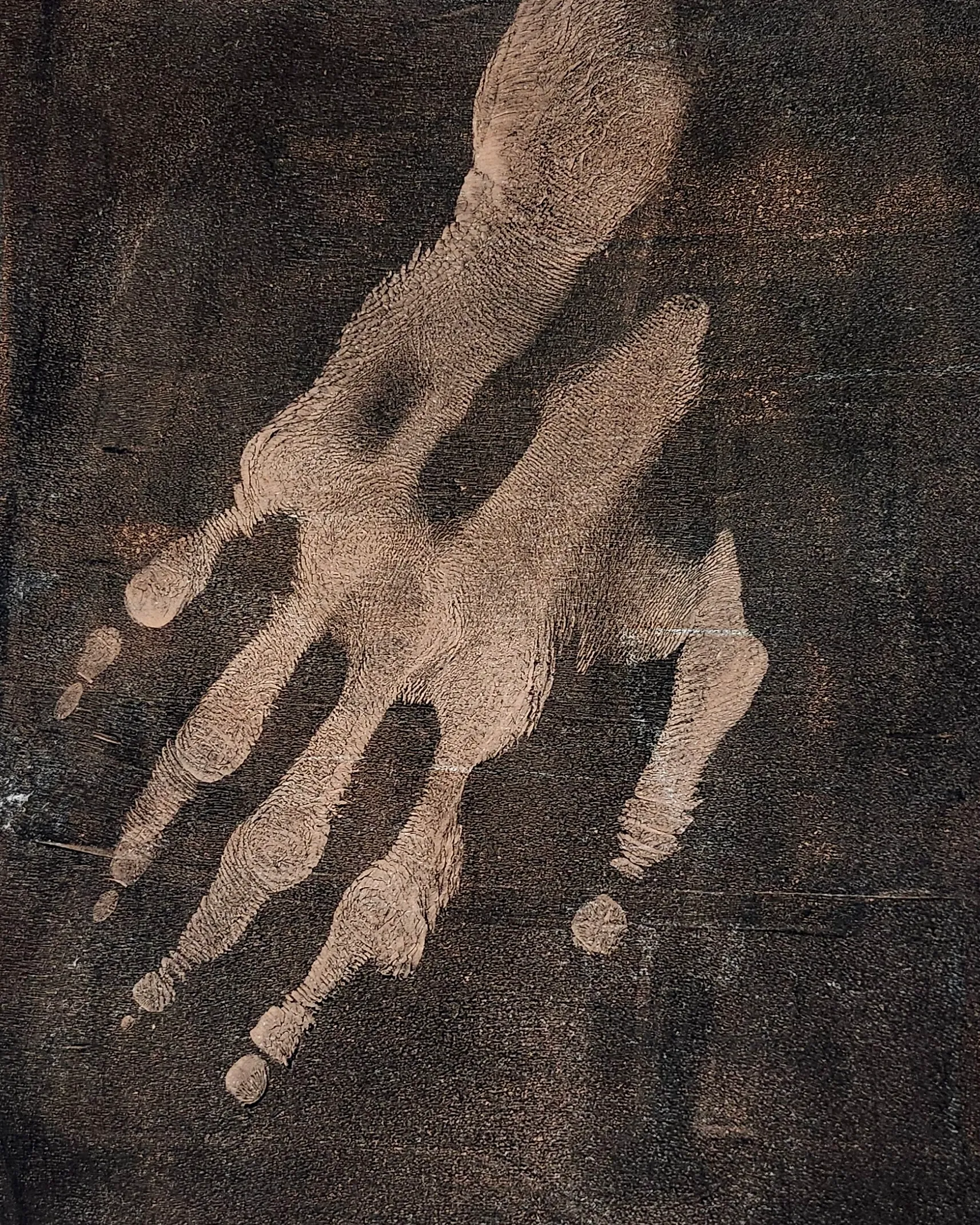 Warm sepia-toned handprint with pronounced ridge texture, fingers spread and reaching diagonally across a dark brown ground.